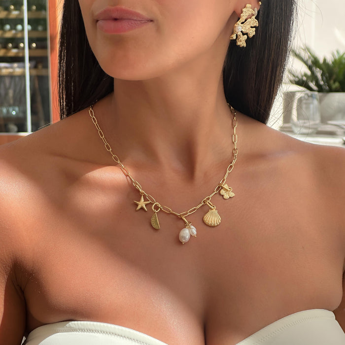 model wearing gold charm necklace with summer inspired charms from prya