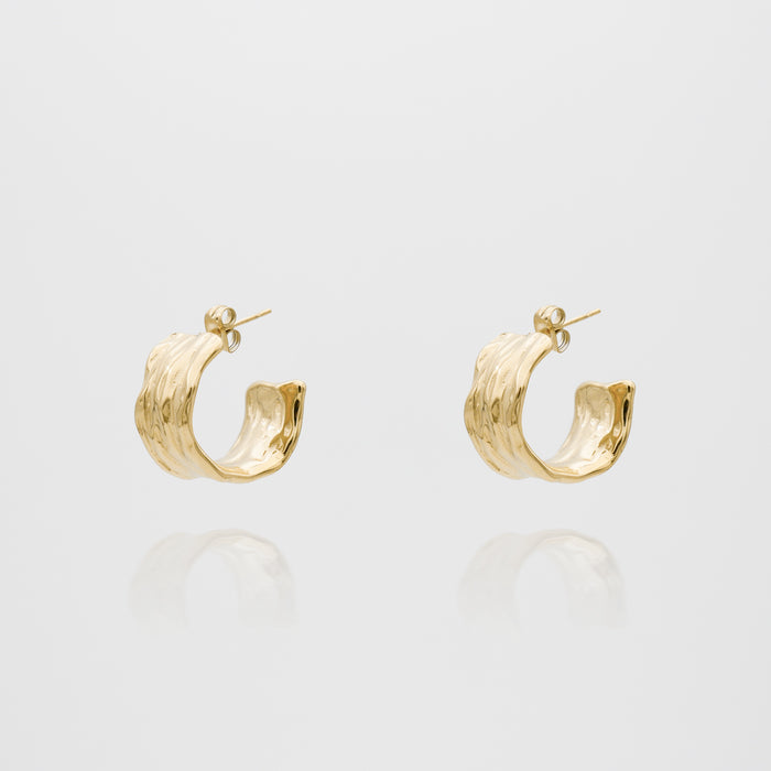 Gold textured hoop earrings on white background.