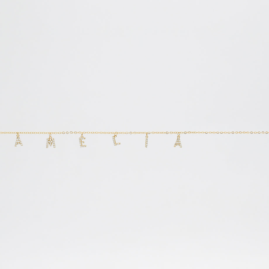 Gold chain with "AMELIA" spelled in letters.