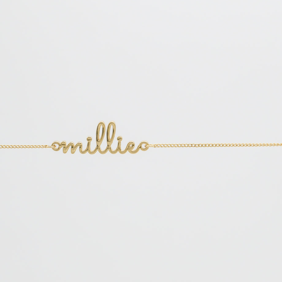 Gold belly chain with "millie" script.