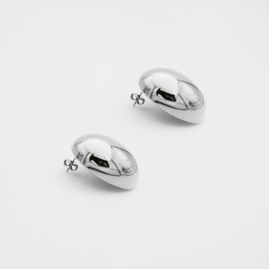 Silver spherical Maeve earrings on white background.