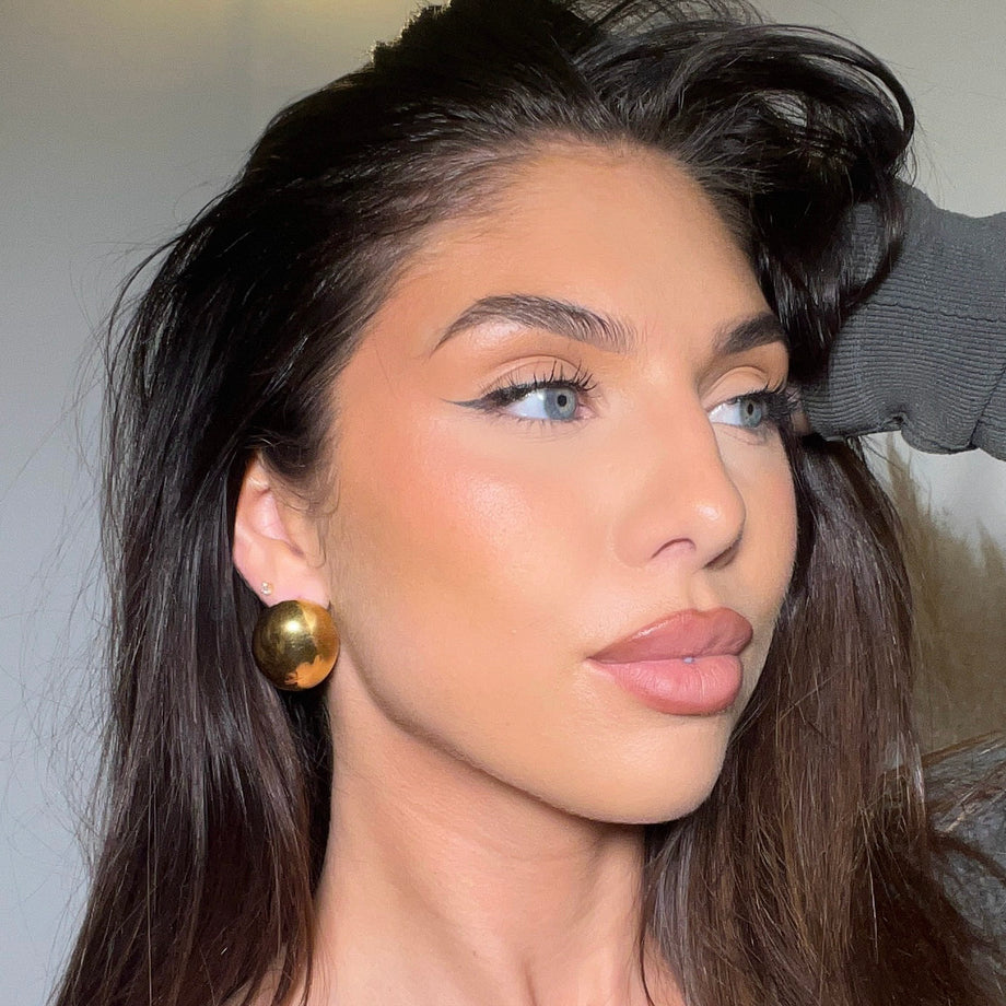 model wearing Gold spherical Maeve earrings