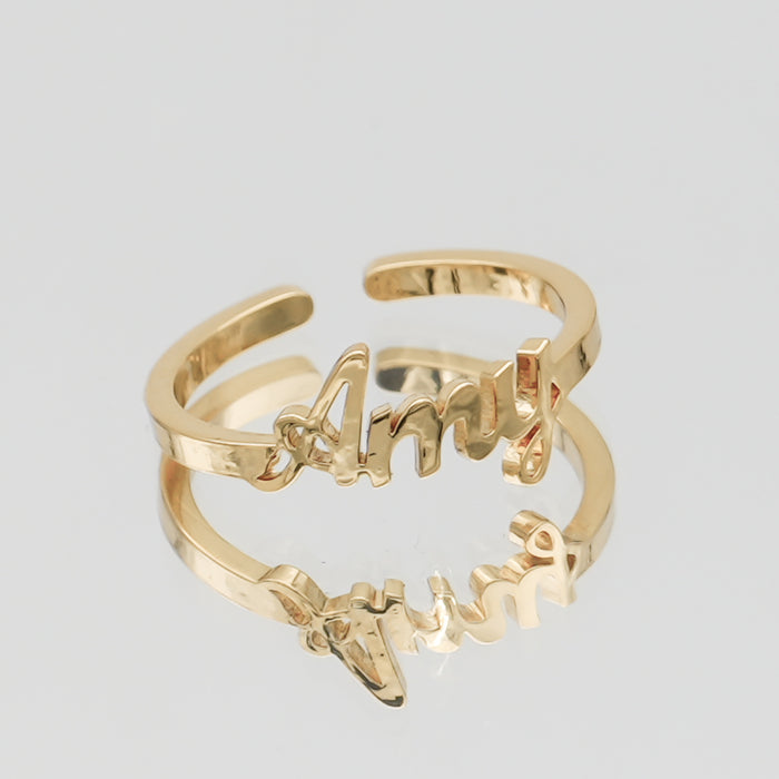 Gold ring with "Amy" in cursive script.