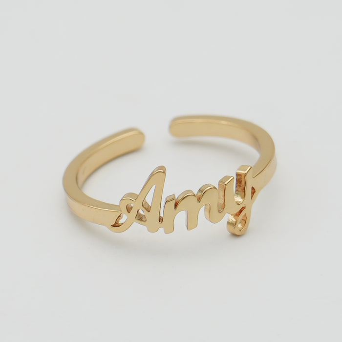 Gold ring with "Amy" in cursive script.