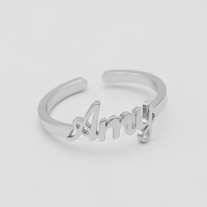 Silver ring with "Amy" in cursive script.