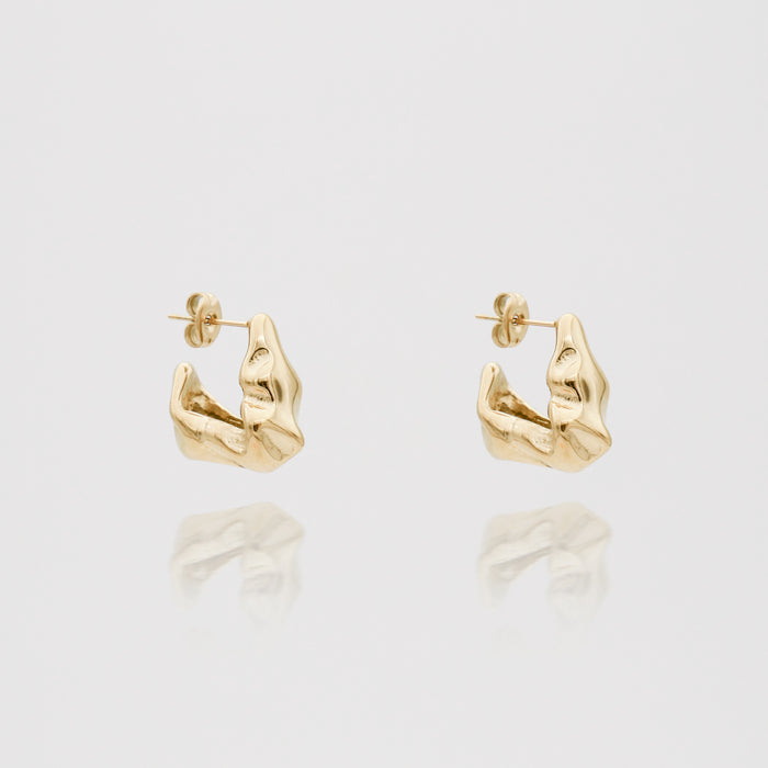 Gold textured hoop earrings on white background.