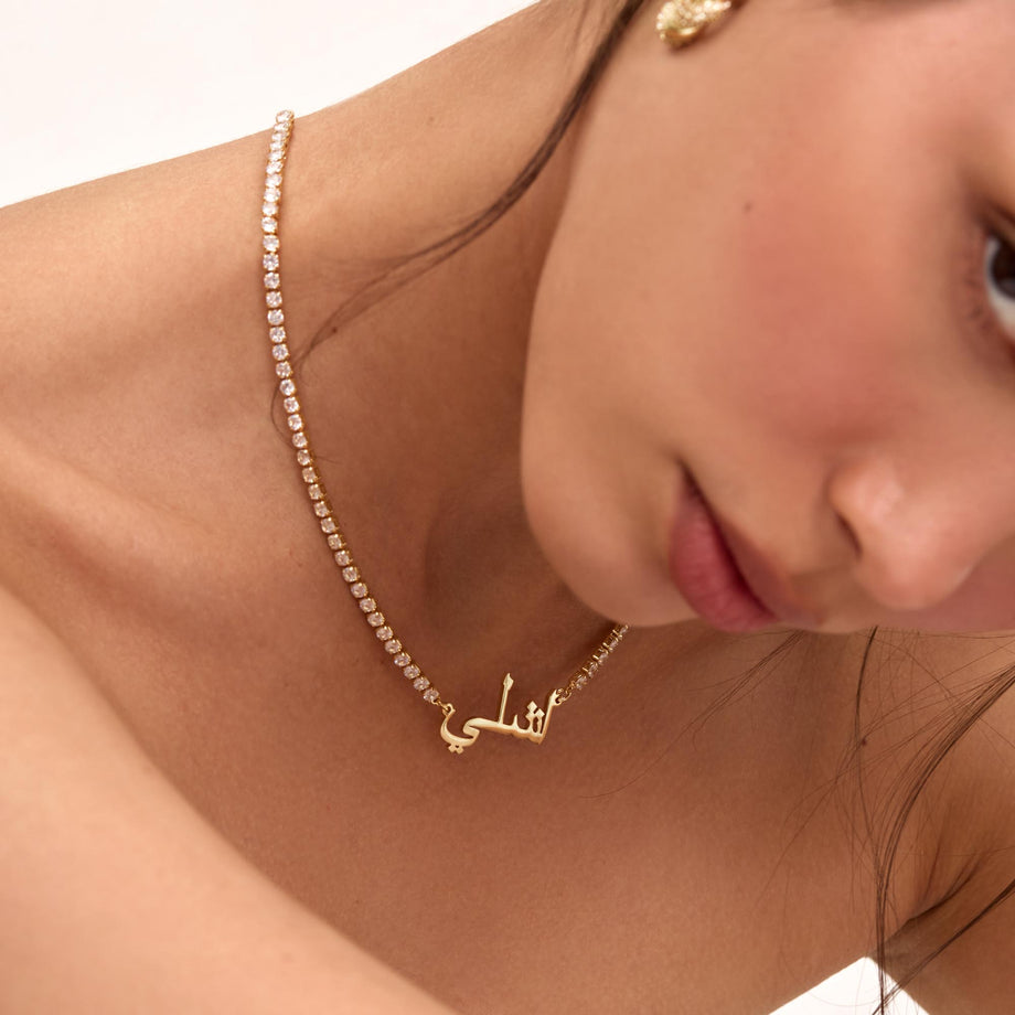 Close up of a model wearing a PRYA gold Icy Arabic Name Necklace
