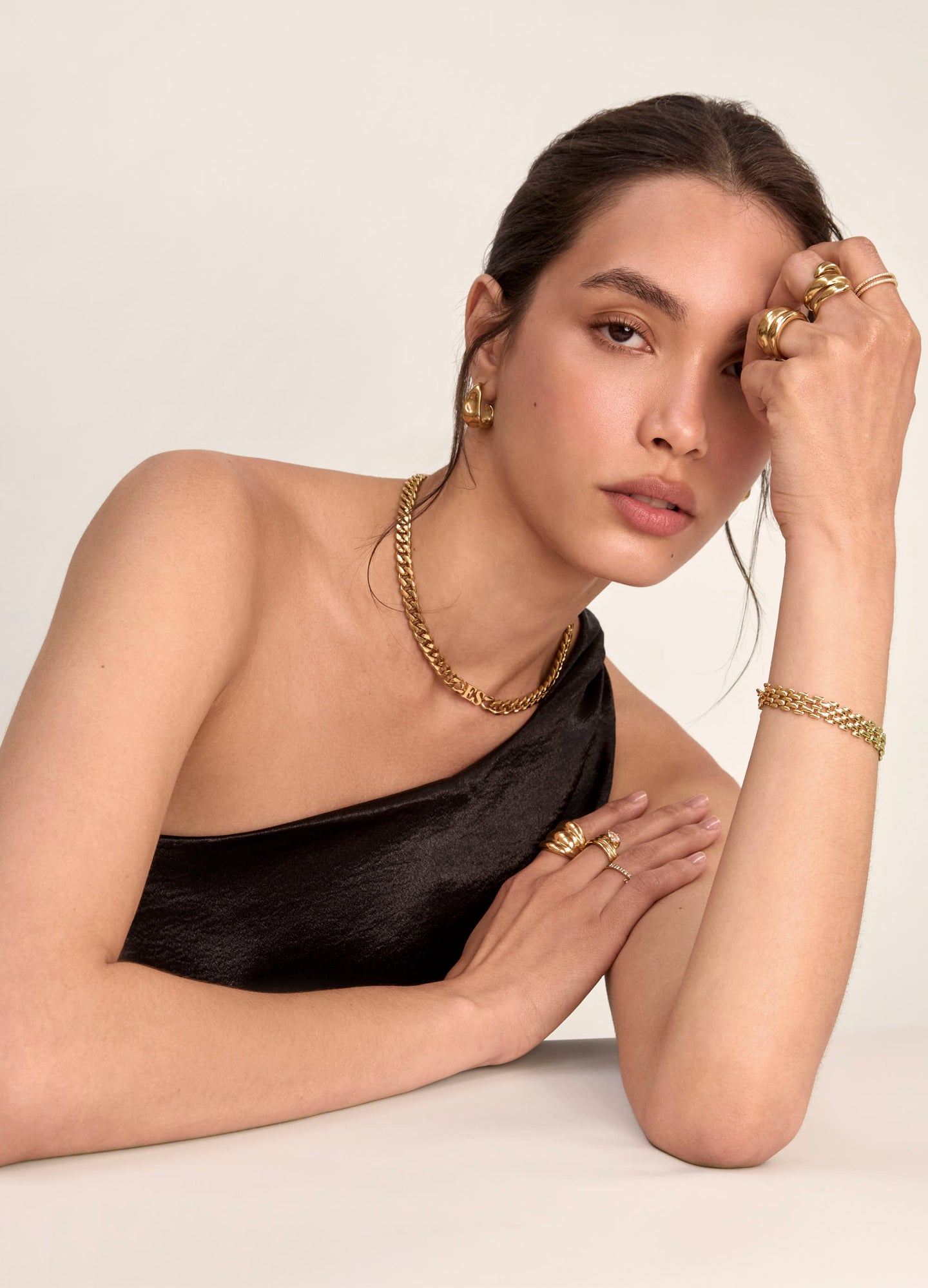 model wearing initial choker necklace in gold with watch strap bracelet, earrings and rings from prya