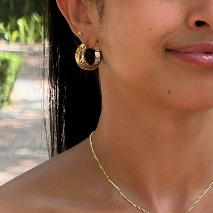 Model wearing rina mixed metal, two tone earring huggie from prya