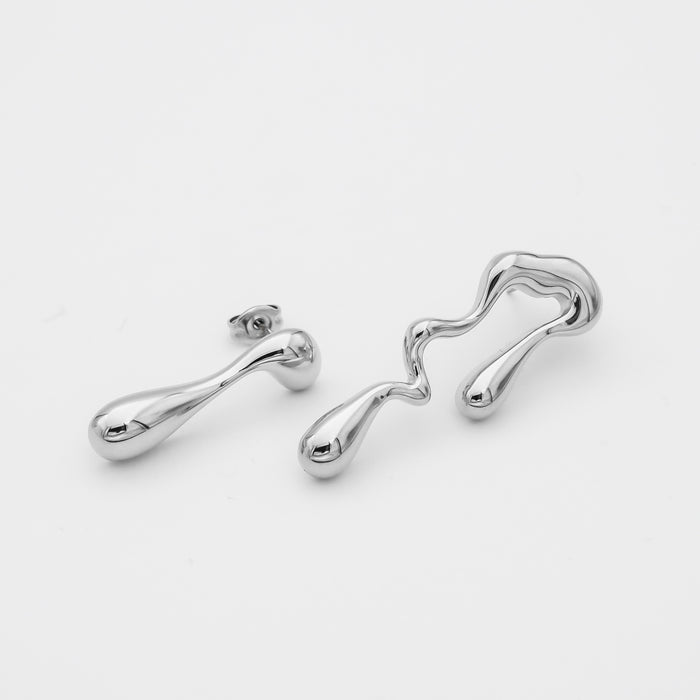 Abstract silver earrings on white background.