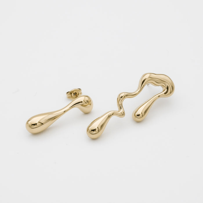 Abstract gold earrings on white background.