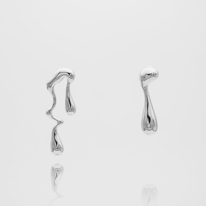 Abstract silver earrings on white background.