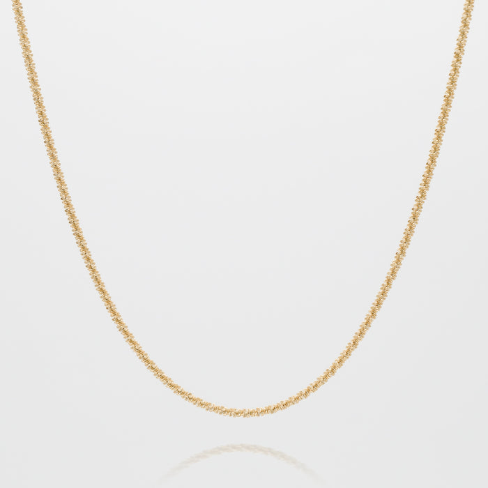 Gold twisted chain necklace on white background.