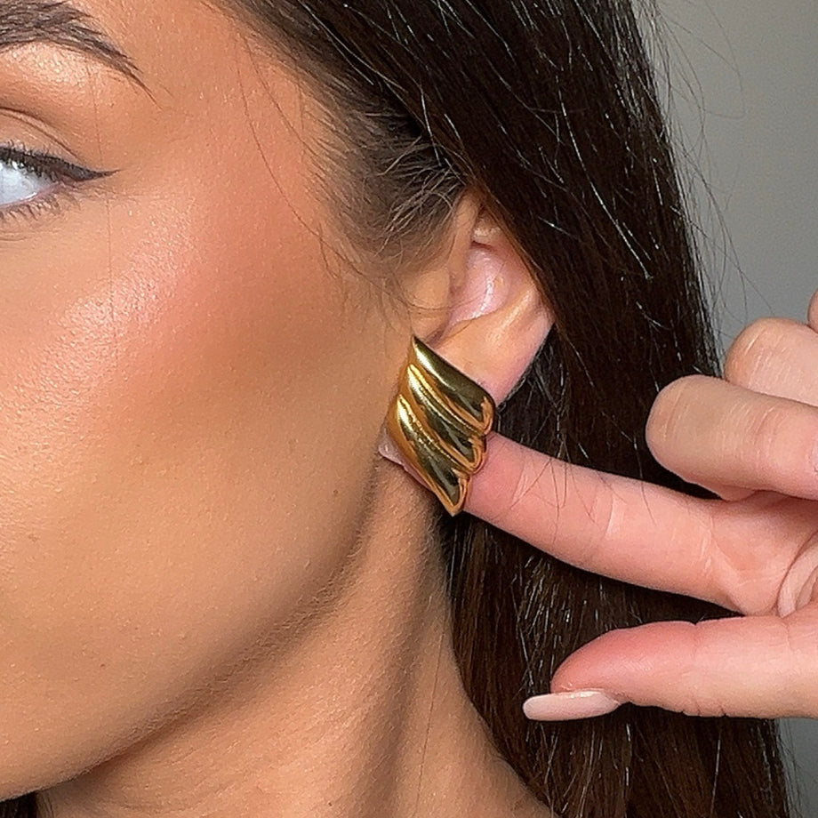 model wearing zaya statement earrings in gold from prya