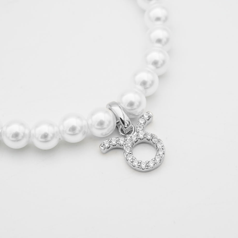 Silver-accented pearl bracelet with zodiac charm.