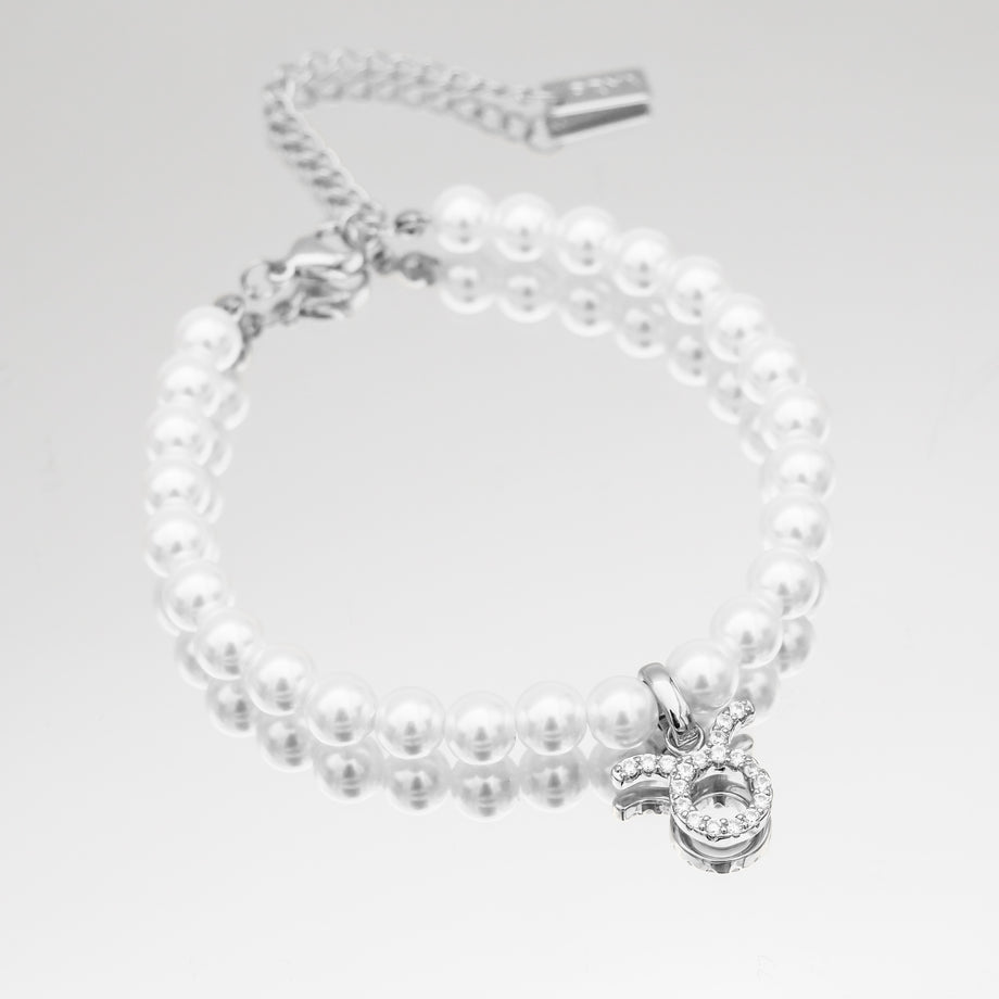 Silver-accented pearl bracelet with zodiac charm.