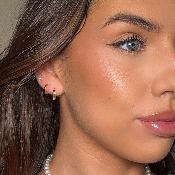 model wearing stack of earrings including the elle gold huggie earring