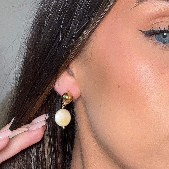 model wearing margot pearl drop earrings in gold from prya