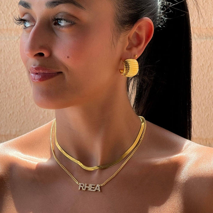 model wearing raise ribbed earrings in gold from prya