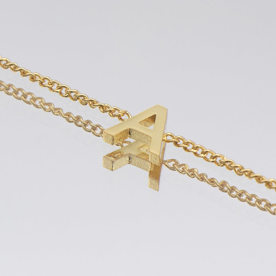 Maia Initial Bracelet in 18k gold featuring a stylish 'A' pendant on a delicate link chain.