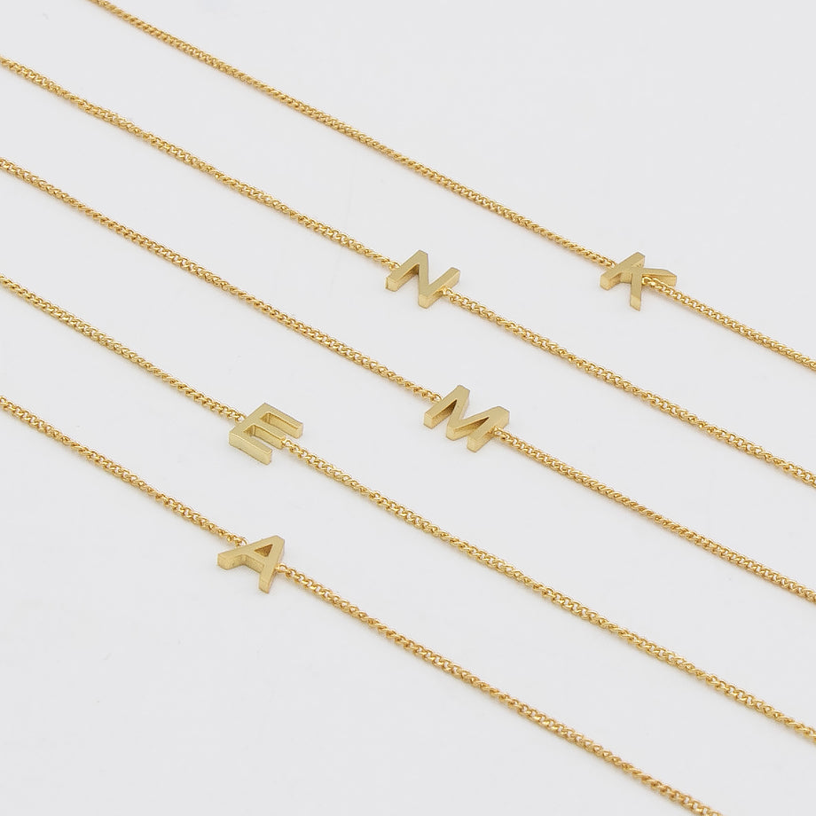 Maia Initial Bracelets featuring gold link chains with letter pendants for personalised elegance.