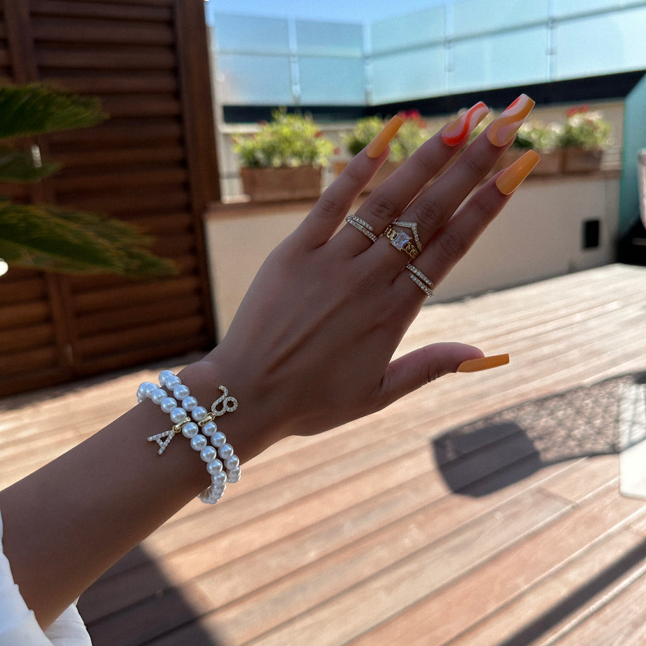 model wearing Gold-accented pearl bracelet with zodiac charm.
