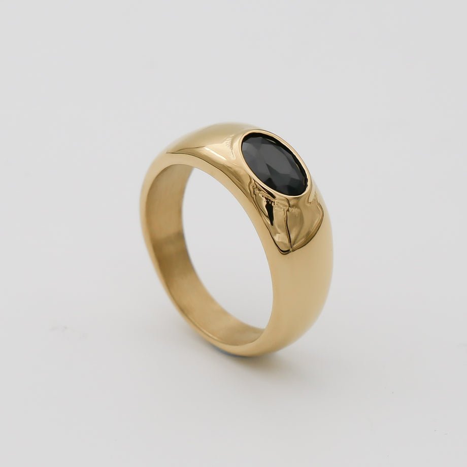 Gold ring with black oval gemstone.