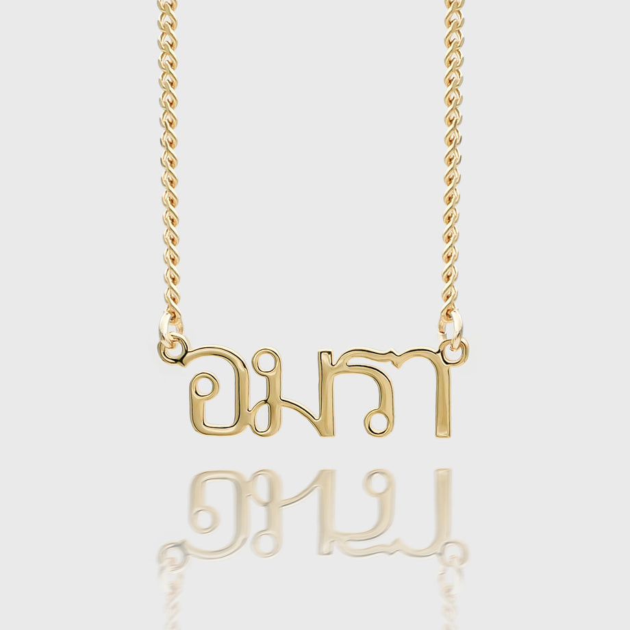 Gold Thai name necklace on a chain.