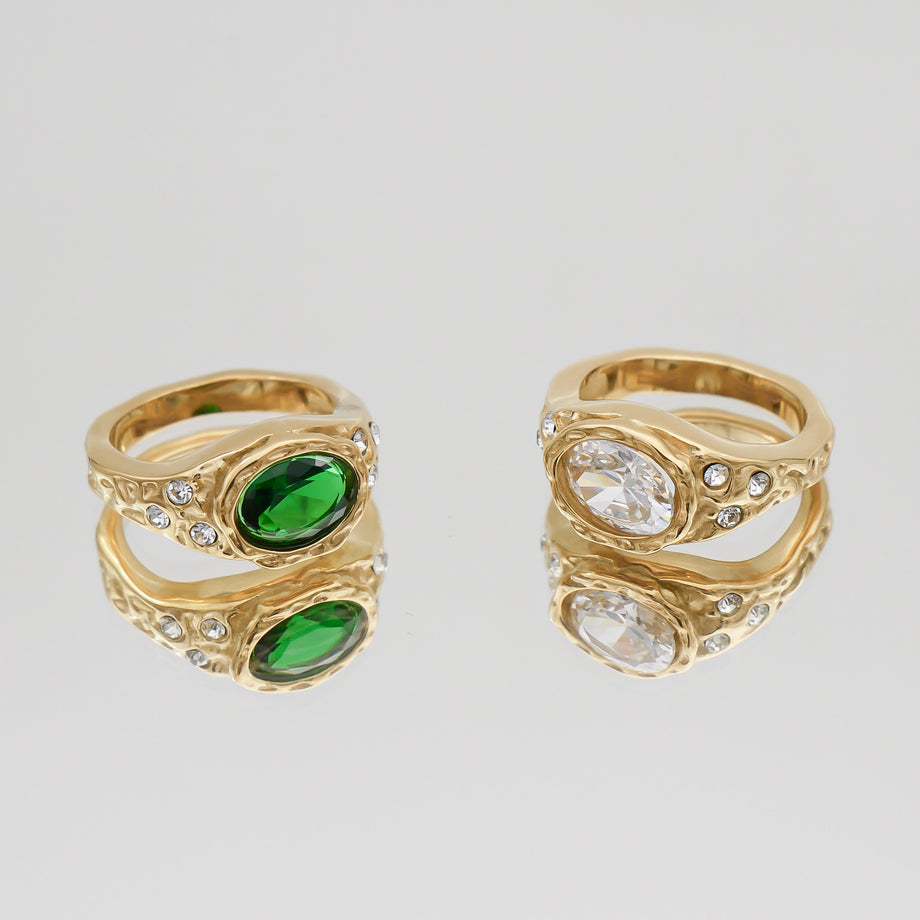 Two gold rings with green and clear stones.