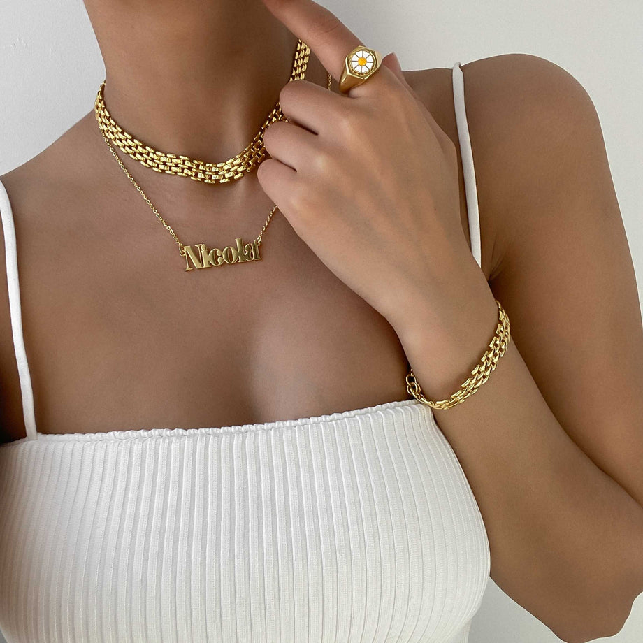 model wearing layered necklaces including custom name necklace in 18k gold plated stainless steel from prya