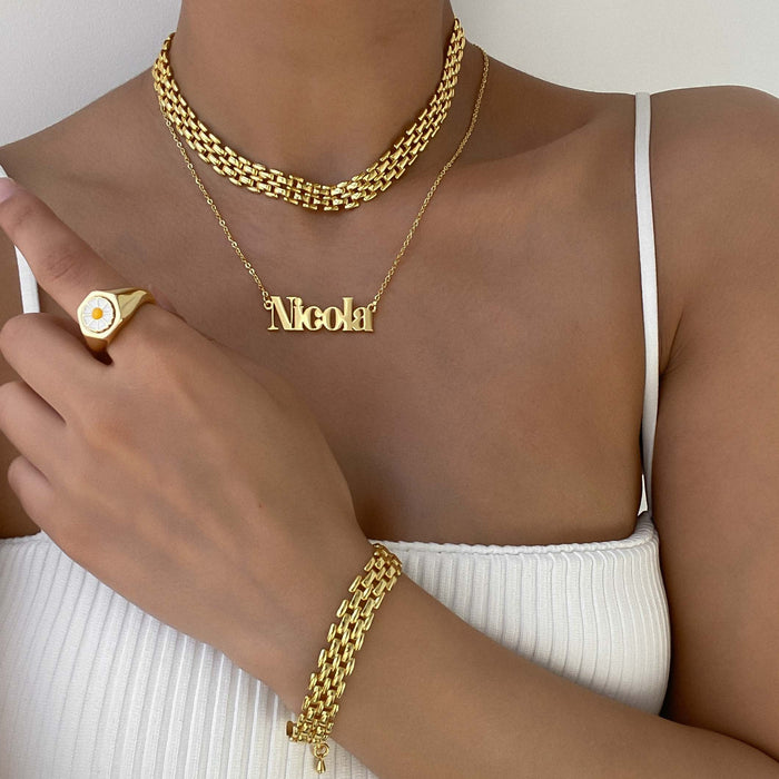 model wearing layered necklaces including custom name necklace in 18k gold plated stainless steel from prya