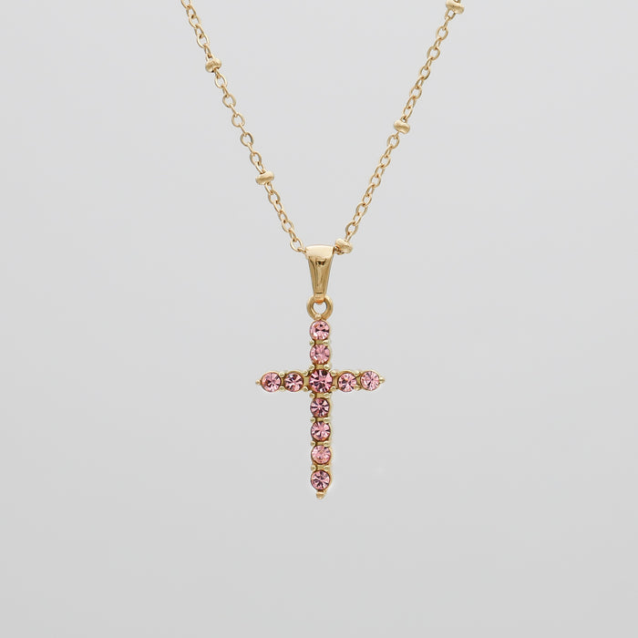 Gold chain with pink gemstone cross pendant.