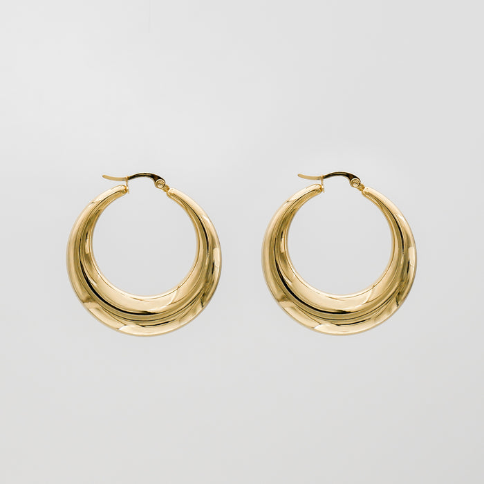 Gold hoop earrings against plain background.