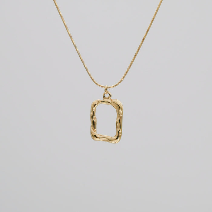 Gold pendant necklace on a thin chain.