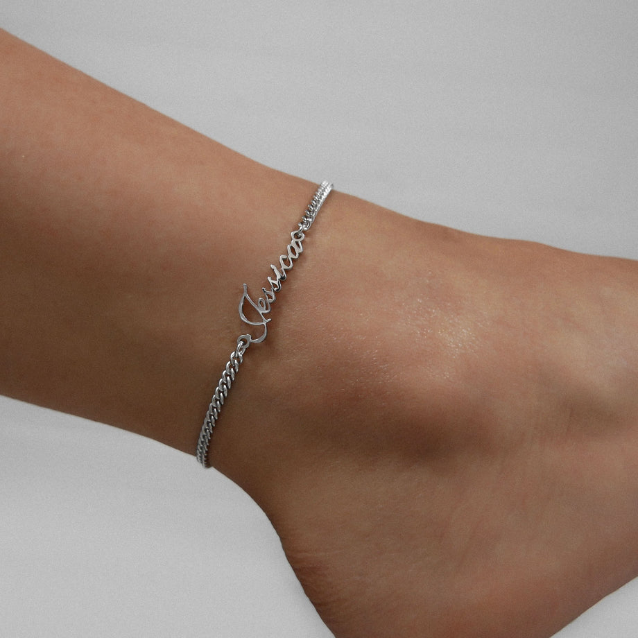 Silver name anklet worn on woman’s ankle