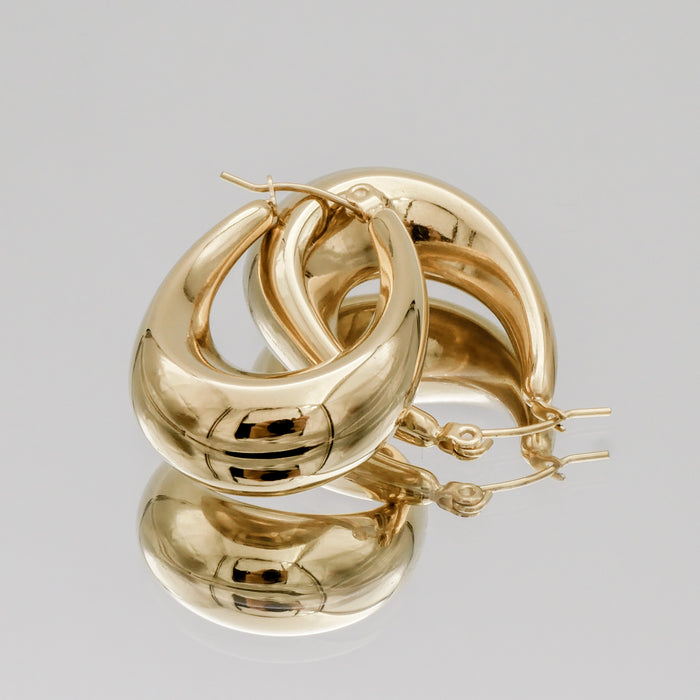 Gold hoop earrings on a plain background.
