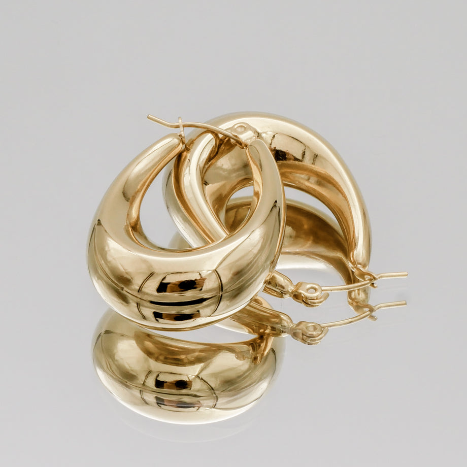 Gold hoop earrings on a plain background.