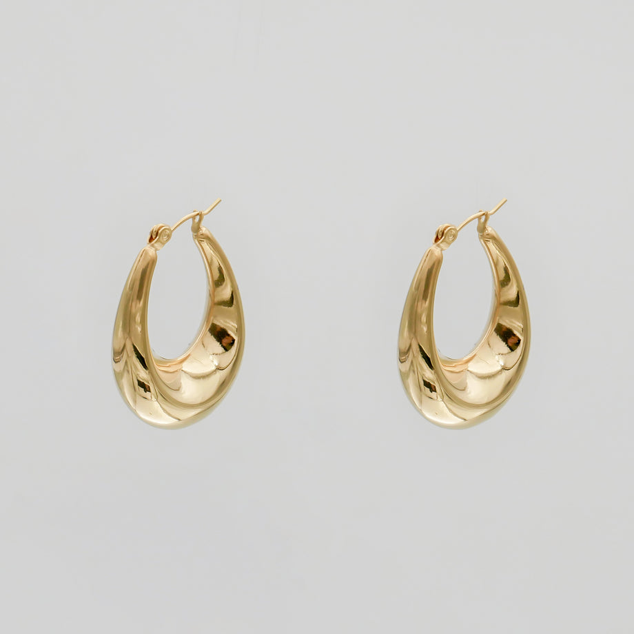 Gold hoop earrings on a plain background.