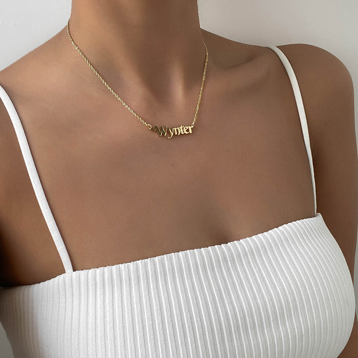 model wearing gold personalised name necklace from prya