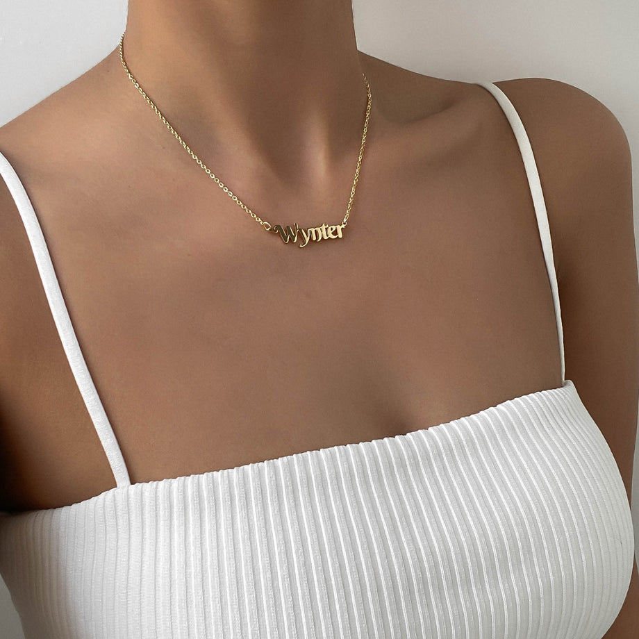 model wearing gold personalised name necklace from prya