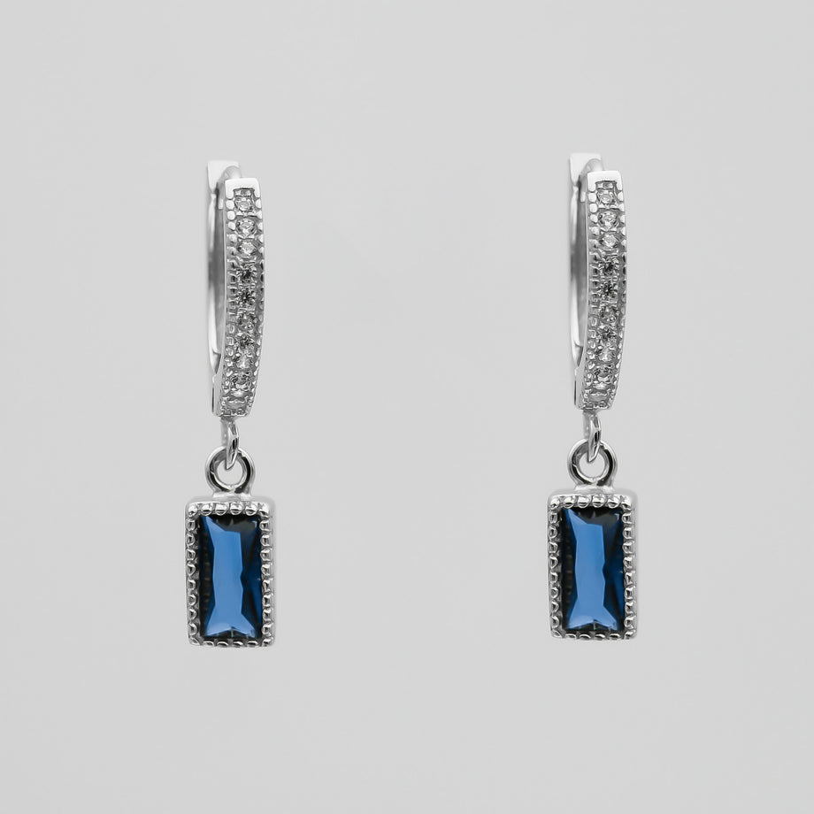 silver pave hoop earrings with blue gemstone pendants.