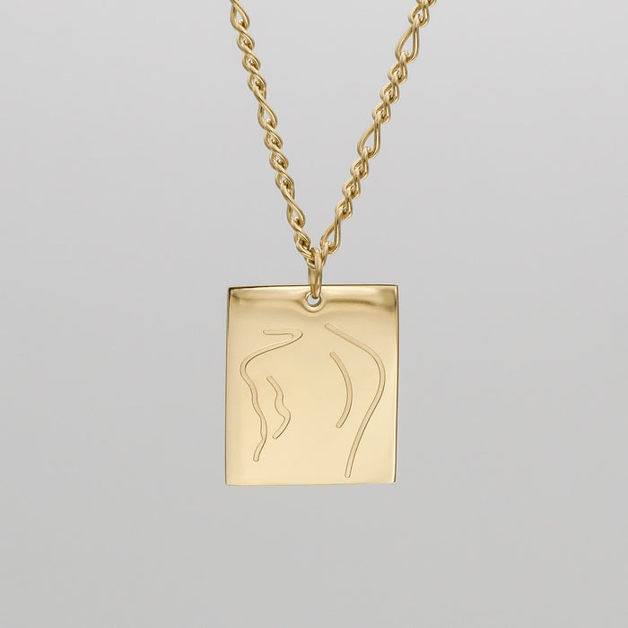 Gold necklace with abstract engraved pendant.