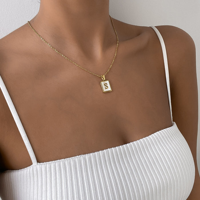 Model wearing the opal initial pendant in gold