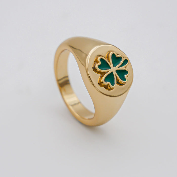 Gold ring with green clover design.