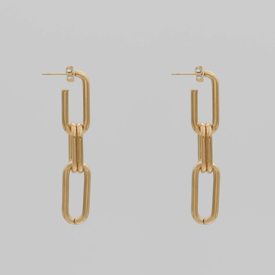 Gold chain adjustable link earrings with two links on grey background.