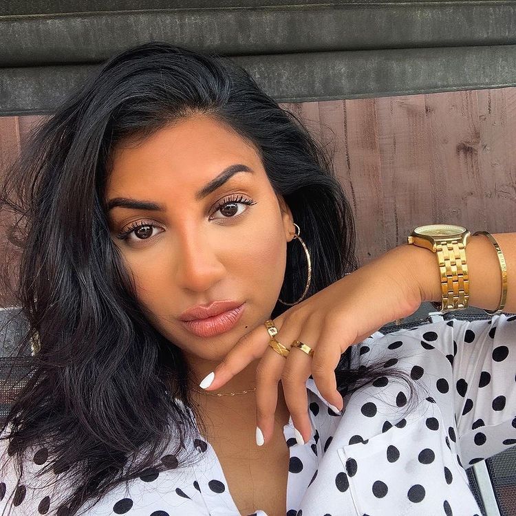 Woman in polka dot white shirt with large hoop earrings that are perfect for work