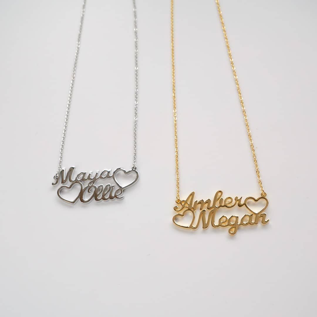 Where To Buy Necklaces With Your Name? Two double name necklaces sit side by side on a white background, one is a silver name necklace, one is a gold name necklace.