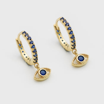 close up of gold evil eye huggie earring paved with sapphire