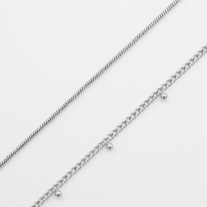  Two delicate silver belly chains on white background