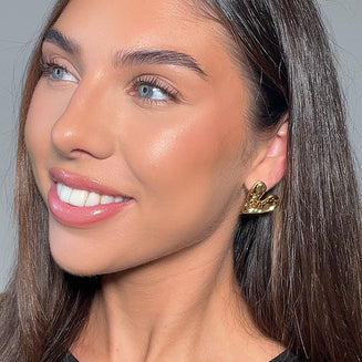 model wearing Cari hammered heart earring in 18k gold plated from prya